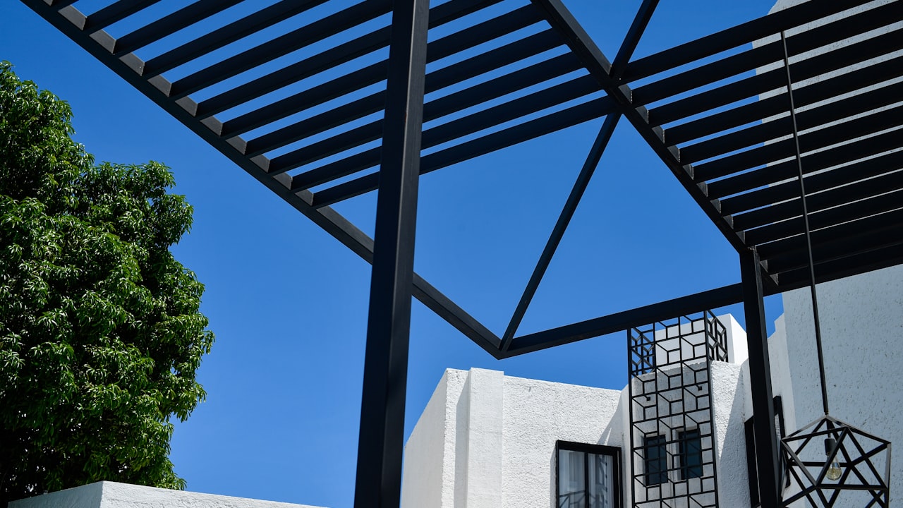 Pergola nad terasou rodinného domu se zahradním posezením